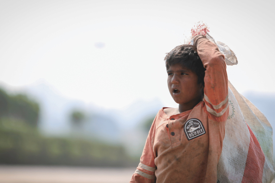 A young child labourer in Pakistan working in a field at sunrise, symbolizing the harsh conditions faced by millions of children who are forced to work instead of attending school.
